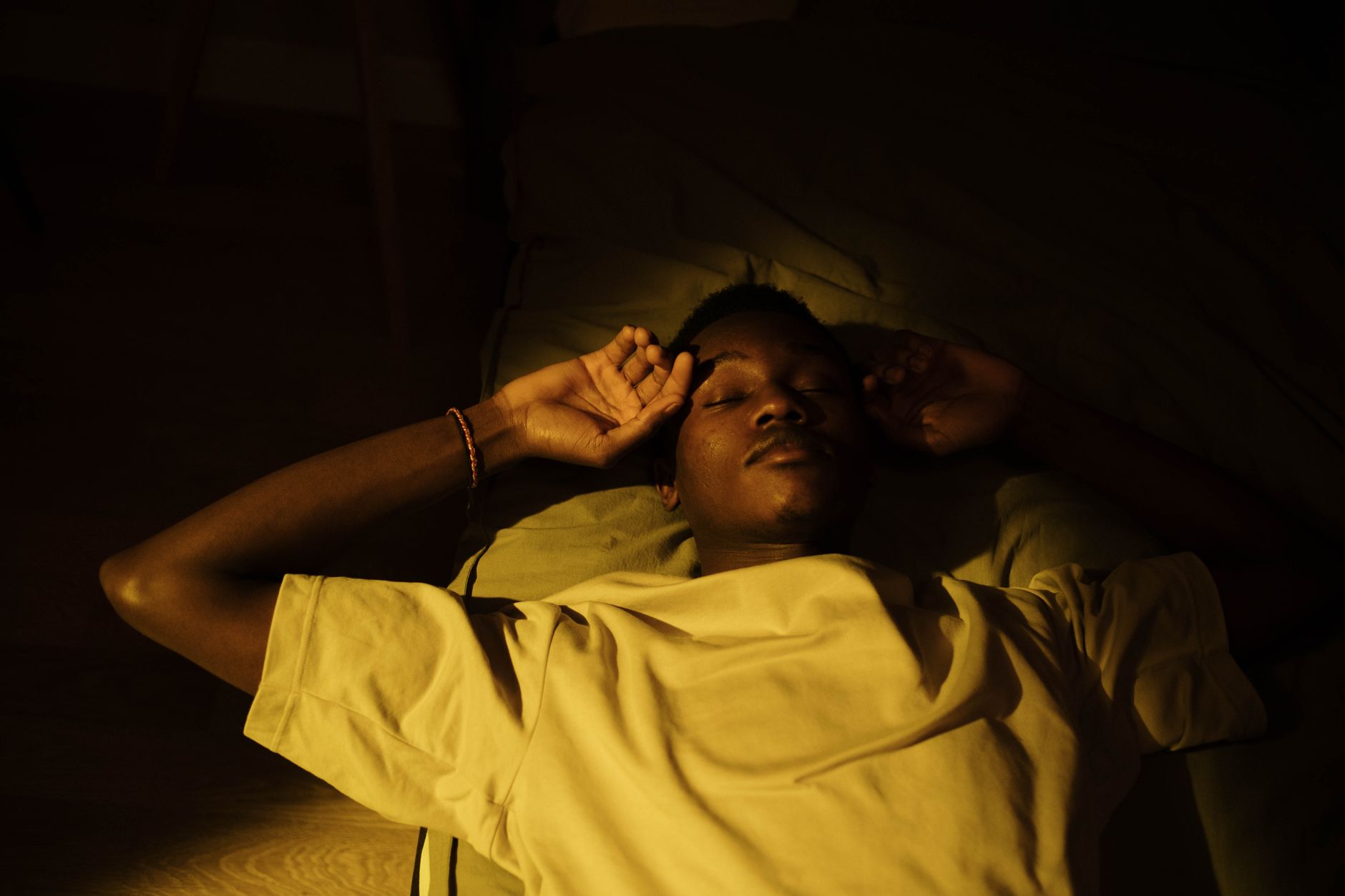 Person sleeping peacefully in a dark bedroom